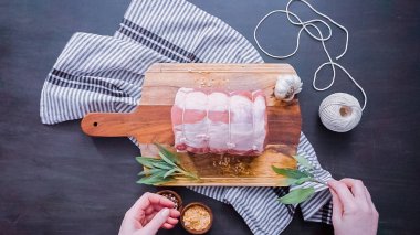 Düz yatıyordu. Adım adım. Ham kemiksiz domuz kızartma baharat ile ahşap kesme tahtası üzerinde.