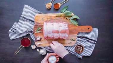 Düz yatıyordu. Adım adım. Ham kemiksiz domuz kızartma baharat ile ahşap kesme tahtası üzerinde.