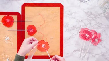 Düz yatıyordu. Büyük ev yapımı lolipopları temiz hediye paketlerine sarıyorlar..