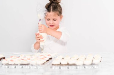 Küçük kız İtalyan tereyağı kreması tatlandırması yapıyor..