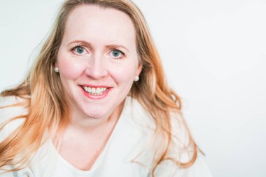 Gülümseyen orta yaşlı kadının stüdyo portresi.