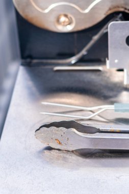 BBQ tools on the side of the outdoor gas grill.