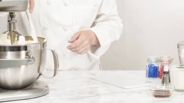 Tereyağlı krema yapmak için mutfak mikserinin malzemelerini karıştırıyorum..