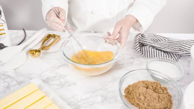 Adım adım. Çikolata parçacıklı kurabiye yapmak için cam kasede malzemeleri karıştırıyorum..