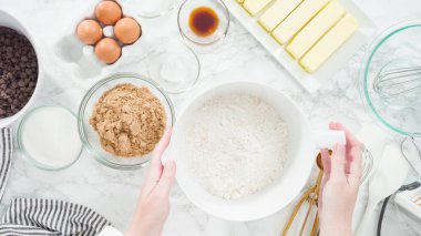 Adım adım. Düz yatıyordu. Çikolata parçacıklı kurabiye yapmak için cam kasede malzemeleri karıştırıyorum..