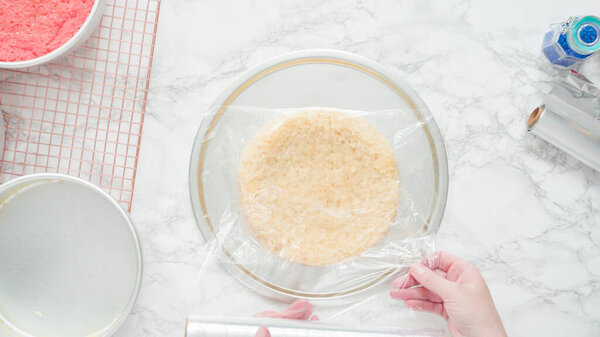 Step by step. Flat lay. Removing freshly baked cake layers from the cake pan to be cooled.