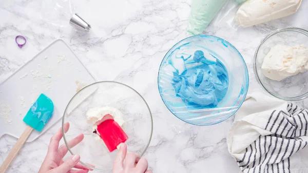 バタークリームの霜降りと食品の着色料を混合 — ストック写真