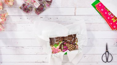 Düz yatıyordu. Adım adım. Ev yapımı şekerleme ve kurabiyeleri Noel hediyesi kutusuna koymak.