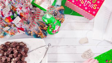 Düz yatıyordu. Adım adım. Ev yapımı macadamia şekerlemesi küçük hediye paketlerine konuyor..