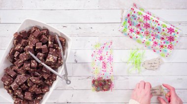 Düz yatıyordu. Adım adım. Ev yapımı macadamia şekerlemesi küçük hediye paketlerine konuyor..