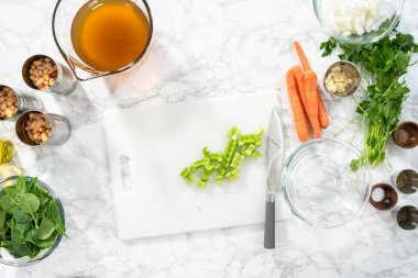 Düz yatıyordu. Beyaz bir kesme tahtasıyla organik kereviz kesmek..