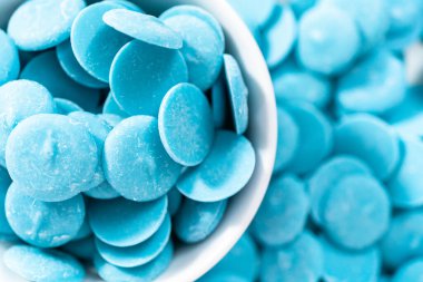 Çikolata şekillerini eritmek için mavi yuvarlak çikolata parçaları.