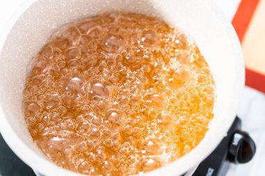 Ev yapımı lolipop yapmak için tencerede karamelize şeker.
