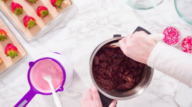 Düz yatıyordu. Adım adım. Çikolata parçacıkları eriyen kaplarda eriyor..