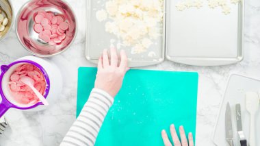 Düz yatıyordu. Adım adım. Fazla çikolatayı, kar taneleri şeklindeki çikolatalardan küçük bir mutfak bıçağıyla budamak..