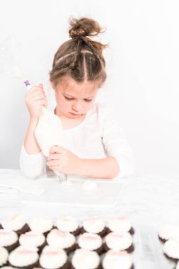 Küçük kız İtalyan tereyağı kreması tatlandırması yapıyor..