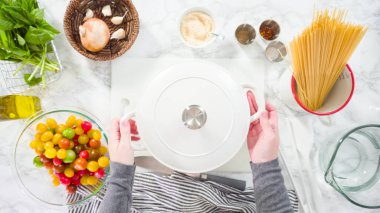 Düz yatıyordu. Adım adım. Tek demlik makarna tarifi yapmak için beyaz bir kesim tahtasıyla sebze kesmek..