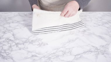 Adım adım. Temiz mutfak havlusunu mermer bir yüzeye katlamak.