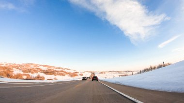 Kış sabahı Amerikan banliyölerinde kırsal bir yolda araba sürerken.