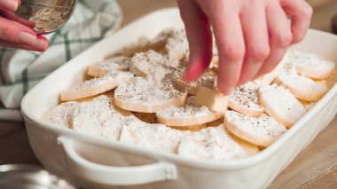 Beyaz seramik bir tencerede istiridyeli patates hazırlıyorum..