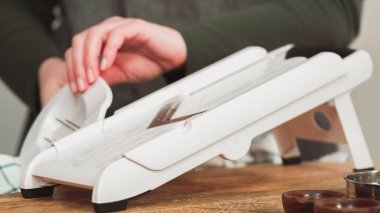 V-Blade mandolininde organik altın patatesleri dilimlemek..
