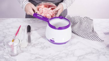 Adım adım. Çikolatalı şekerleri eritmek elektrikli bir şeker tenceresinde erir..