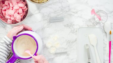 Düz yatıyordu. Adım adım. Erimiş çikolatayı kar taneleri şeklinde plastik bir çikolata kalıbına döküyorum..