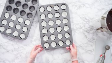 Düz yatıyordu. Adım adım. Mini çikolatalı kek pişirmek için kek kalıplarıyla kek tepsisi hazırlıyorum..