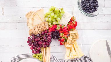 Düz yatıyordu. Adım adım. Taze meyve, gurme peynir ve kraker ile peynir tabağı hazırlıyorum..