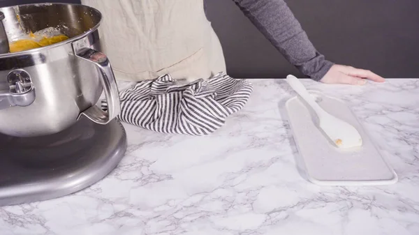 Mixing ingredients in electric kitchen mixer to bake pumpkin spice cupcake.