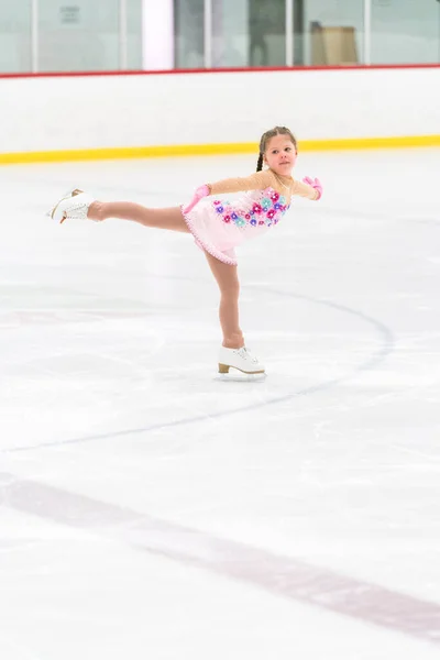 Kleines Mädchen Übt Eiskunstlauf Auf Einer Überdachten Eisbahn — Stockfoto