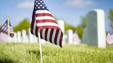 Denver, Colorado, ABD-26 Mayıs 2019 - Anma Günü 'nde Fort Logan Ulusal Mezarlığı' nda beyaz mermer mezar taşlarının yanında küçük Amerikan Bayrakları.