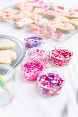 Sevgililer günü için kalp şekli şekerli kurabiye Kraliyet buzlanma ve pembe sprinkles ile dekorasyon.