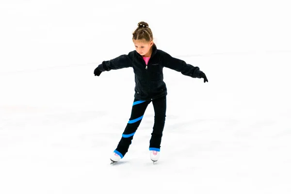 屋内の氷のアリーナで練習黒服の小さなフィギュアスケート — ストック写真