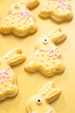 Farklı renklerde kraliyet kremalarıyla süslenmiş Paskalya şekerli kurabiyeler..