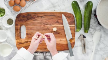 Düz yatıyordu. Adım adım. Sarımsağı ezip kabak keki tarifine ekliyorum..