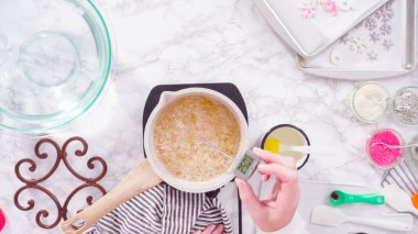 Düz yatıyordu. Adım adım. Küçük elektrikli ocağın üzerinde küçük bir tencerede karamelize şeker.