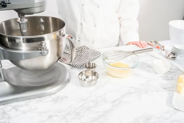 Mixing ingredients in standing kitchen mixer to bake vanilla cupcakes.