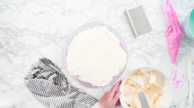 Düz yatıyordu. Adım adım. Beyaz İtalyan kremalı, yuvarlak funfetti keki..