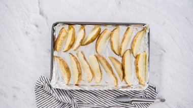 Düz yatıyordu. Adım adım. Fırında pişirmek için zeytinyağı ve baharatlı patatesler hazırlıyorum..