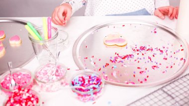 Adım adım. Küçük kız Kraliyet krema ve şeker ile şekerli kurabiye Sevgililer günü için decarting.