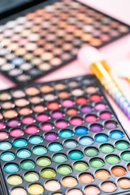 Pembe arka planda makyaj fırçaları olan yeni bir göz falı..