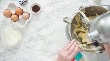 Adım adım. Düz yatıyordu. Üç katlı vanilyalı kek pişirmek için mutfak mikserinin malzemelerini karıştırıyorum..