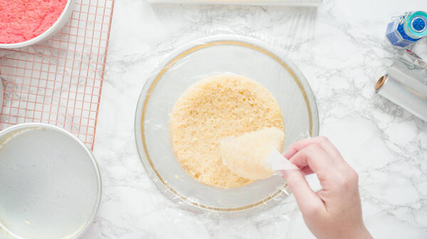 Step by step. Flat lay. Removing freshly baked cake layers from the cake pan to be cooled.