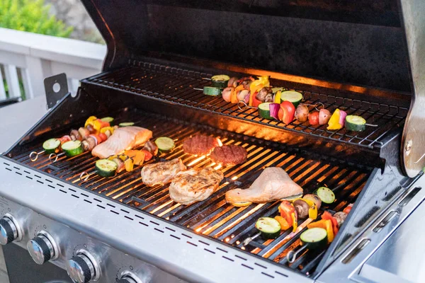 在室外烤架上烤大西洋鲑鱼 鸡胸肉 蔬菜串和素食汉堡 — 图库照片