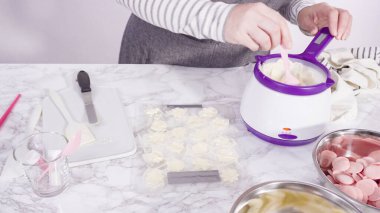 Adım adım. Erimiş çikolatayı kar taneleri şeklinde plastik bir çikolata kalıbına döküyorum..