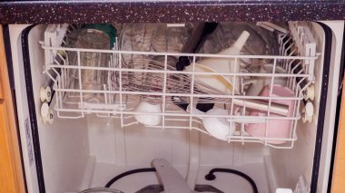 Konut mutfağındaki bulaşık makinesinde bulaşık yıkama..