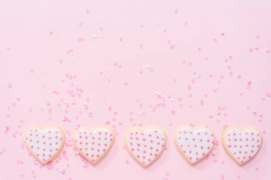 Düz yatıyordu. Bir pembe royal Icing Sevgililer günü için kalp şeklinde şeker kurabiye süslenmiş.