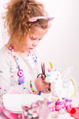 Küçük kız yapma tek boynuzlu at heykel dışında çok renkli köpük levhalar.