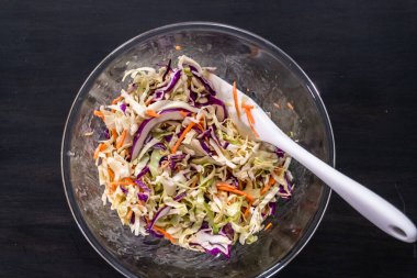 Düz yatıyordu. Cam bir kase içinde ev yapımı coleslaw yapma.